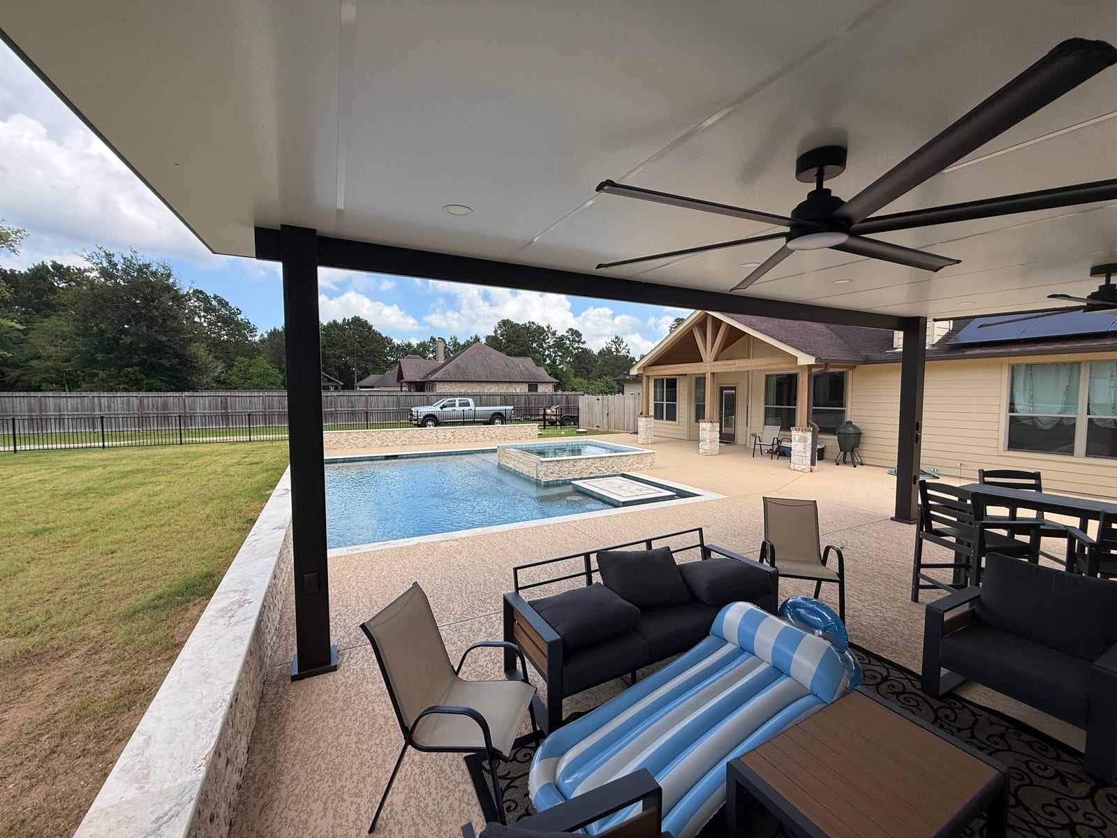 Lounge seating under the covered patio beside the pool deck