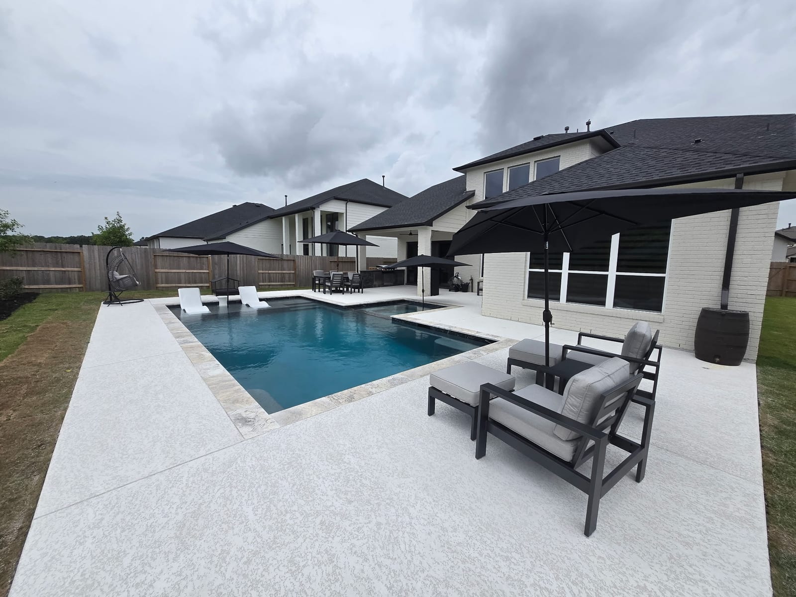 The pool and spa seen along the length of the deck toward the house