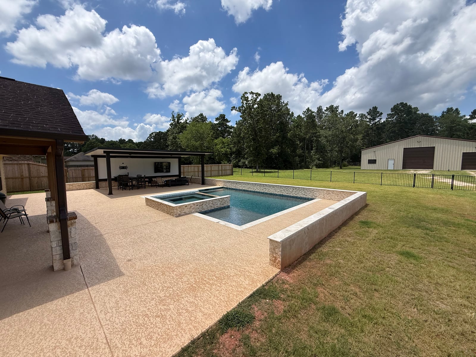 Timber pergola at the corner of the deck beside the raised pool and spa